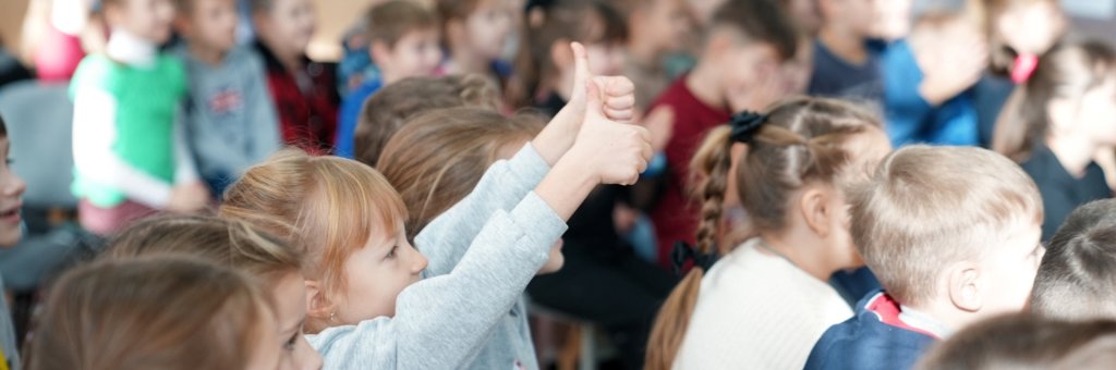 Ett barn i ett publikhav som gör två tummar upp