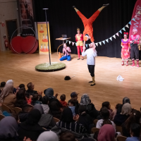 Stor publik och srtister som uppträder med akrobatik på scenen