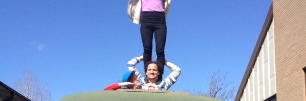 En person balanserar en annan på axlarna genom tackluckan på en buss