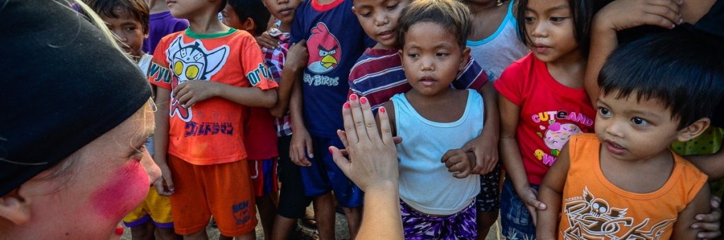 En clown hälsar på en grupp barn