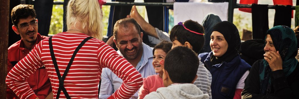 Clown med skrattande publik av både vuxna och barn