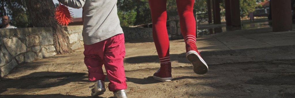 En clown går håller ett barn i handen