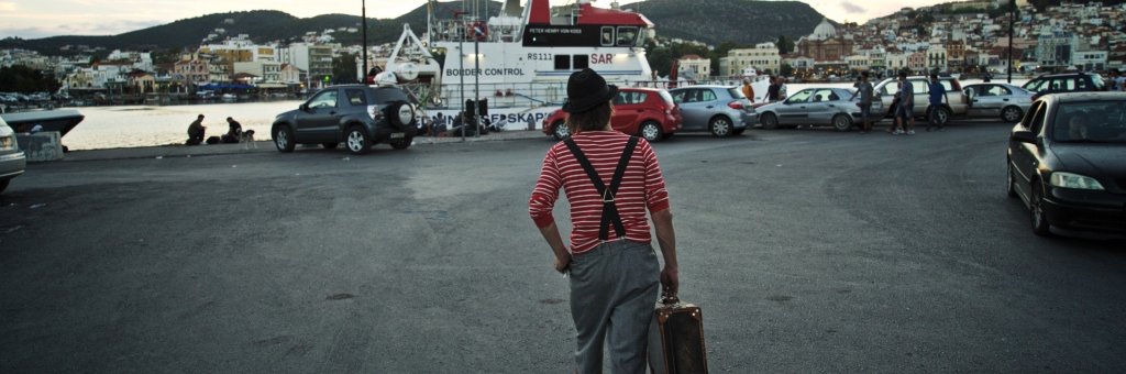 Clown med resväska på väg mot en färja