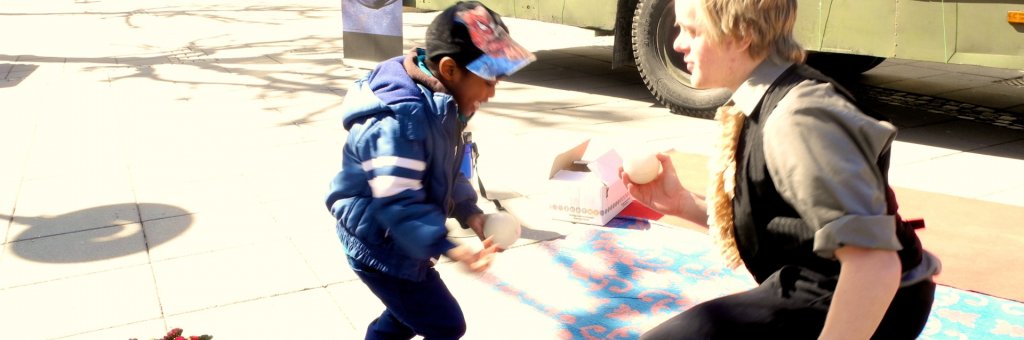 Clown leker med ett barn med tre vita bollar