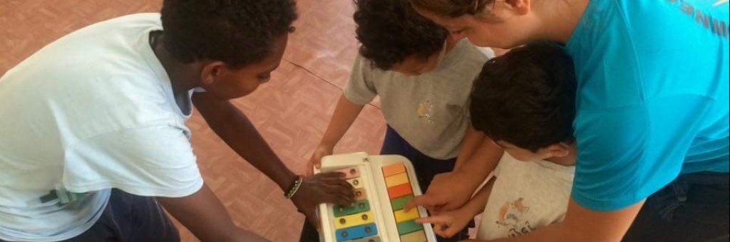 Vuxna och barn spelar på ett färgglatt barninstrument