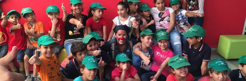 Clown omgiven av glada barn