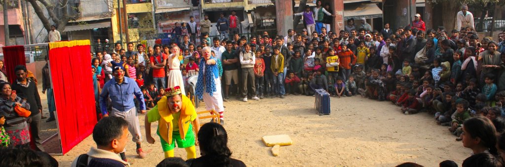 En grupp clowner uppträder i en cirkel av hänförda åskådare