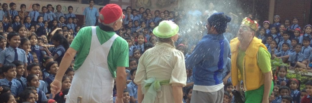 Fyra clowner uppträder inför en stor hänförd publik av barn