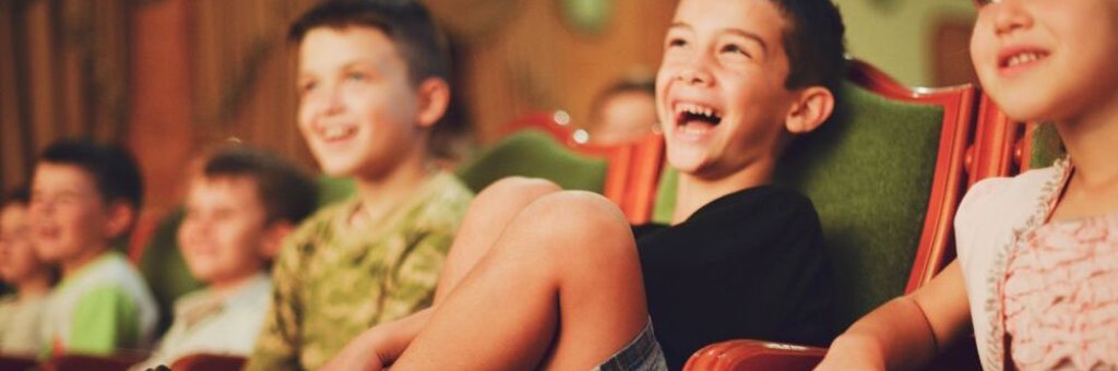 Publikbild på tre barn som skrattar