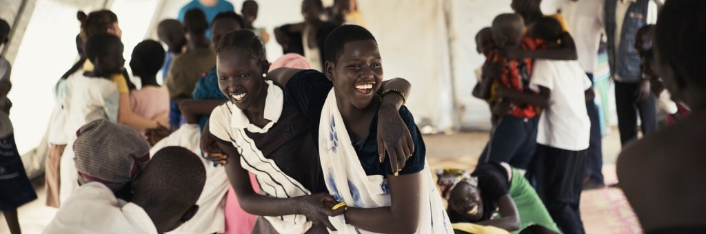 Två flickor håller om varandra och ler