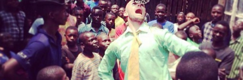 Clown balanserar ett på näsan omgiven av hänförd publik