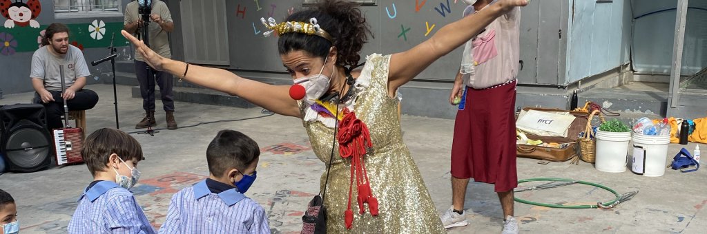 Clown i guldklänning uppträder