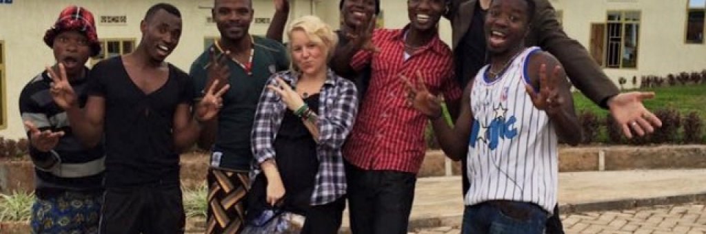 Artisterna poserar tillsammans framför en skola