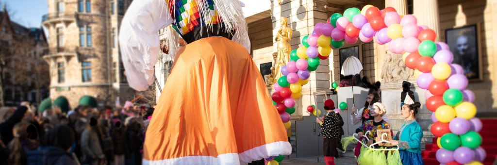 En färgglad ballongbåge och artister framför Dramaten
