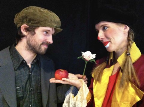 två artister tittar på varandra med ett äpple i handen