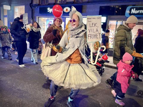 Barn och clowner i färgglad parad