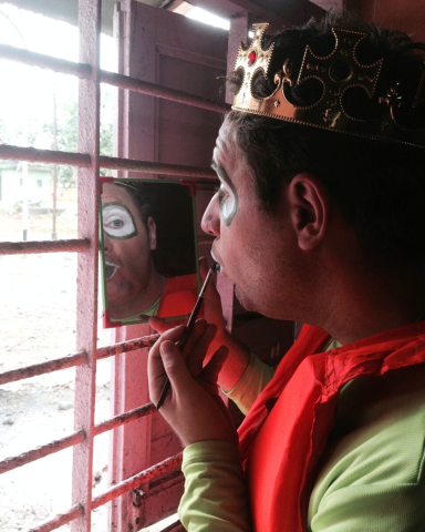 artist sminkar sig vid ett gallerfönster