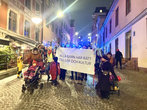 Parad med barn vuxna och clowner genom Stockholms gator.