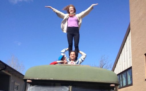 En person balanserar en annan på axlarna genom tackluckan på en buss