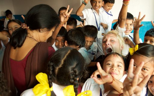Clown omgiven av barn som ler och gör v-tecknet