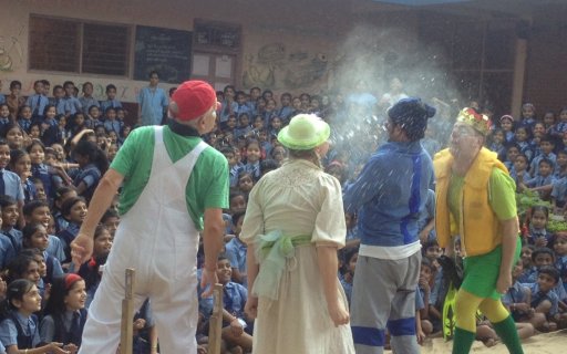 Fyra clowner uppträder inför en stor hänförd publik av barn