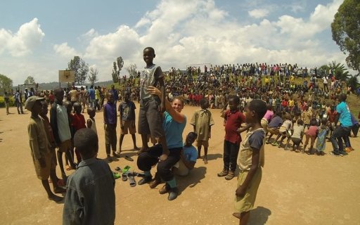 En clown balanserar ett ett barn på sona knän omgiven av andra barn